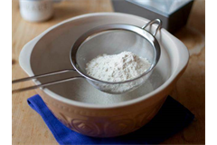 flour in a sifter over a large bowl