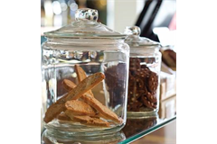 two cookie jars placed on glass racking filled with cookies 