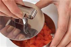 silver cooking ring filled with chopped carrots