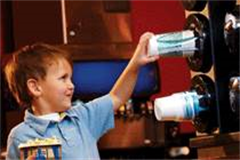 little boy taking cup from a cup dispenser at the cinema