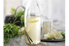 a tall glass bottle filled with cloudy lemonade 