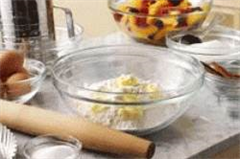 glass bowls placed on a table top filled with ingredients for baking  