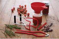 a variety of jam making utensils on a table top 