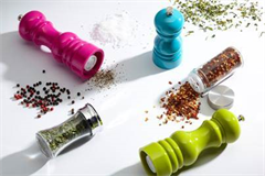 a variety of salt and pepper mills with condiments spread over the table 
