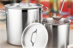 two large stainless steel pots with ladle full of soup 