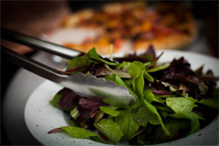 tongs being used to grab salad