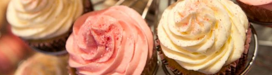 pink iced cup cakes on wire display stand 