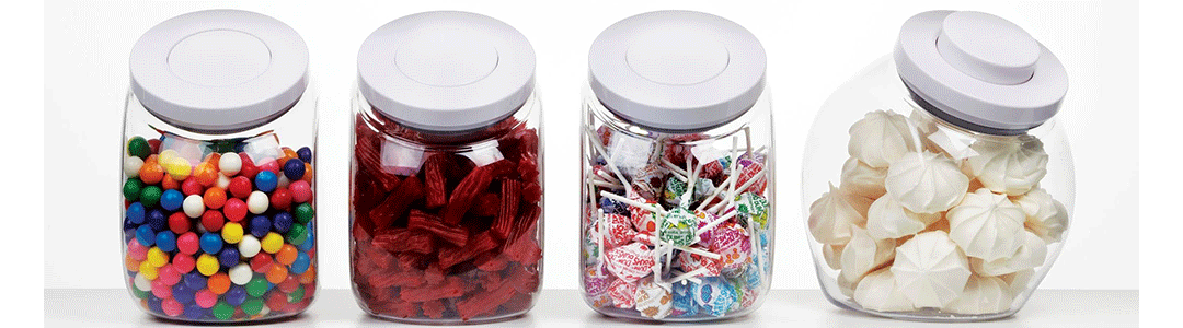 four cookie jars in a row filled with various tasty sweets 