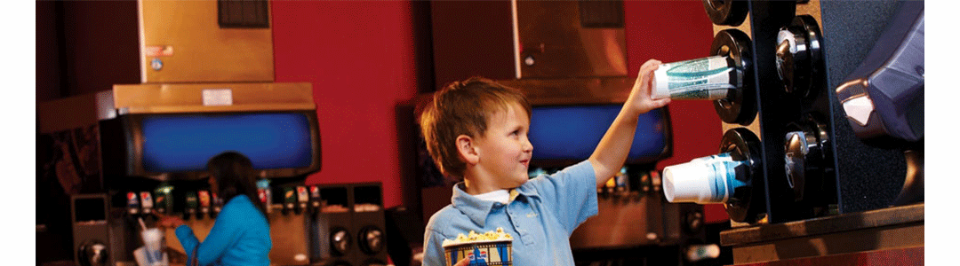 little boy taking cup from a cup dispenser at the cinema