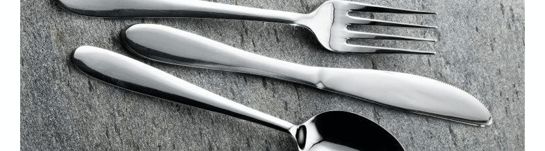 a knife, fork and spoon placed on a table top