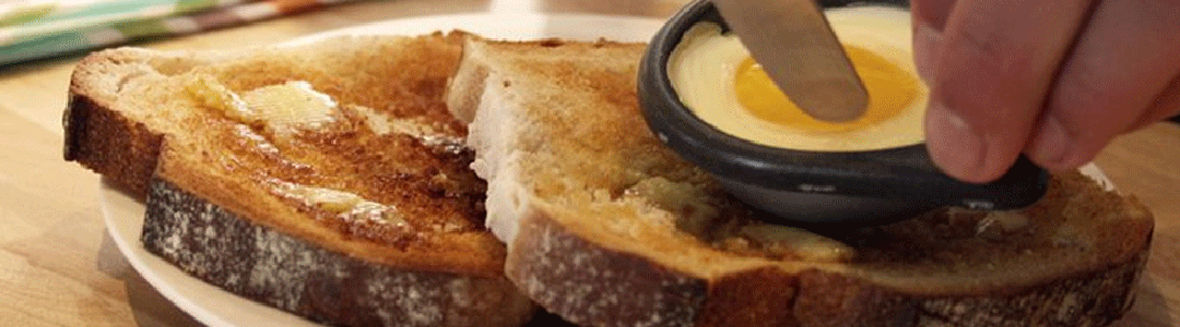 poached egg being added to 2 slices of buttered toast