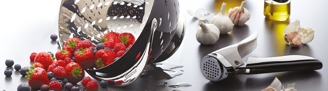 garlic press laying on a busy kitchen work top