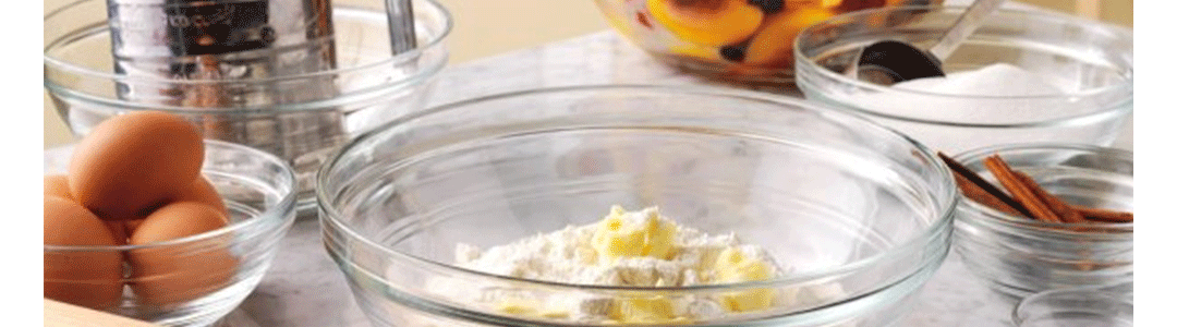 glass bowls placed on a table top filled with ingredients for baking  