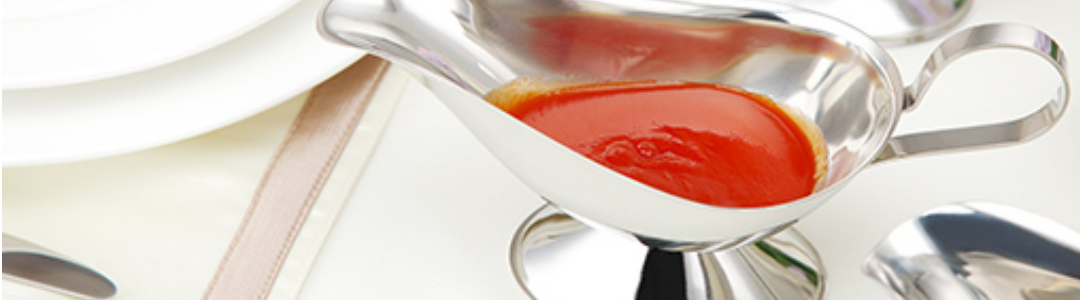 metal gravy boat containing a red sauce