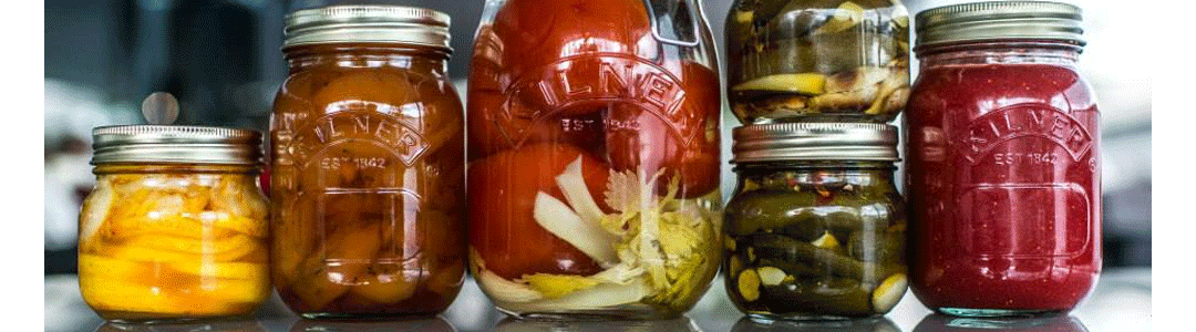 an assortment of jam jars placed side by side filled with various foods