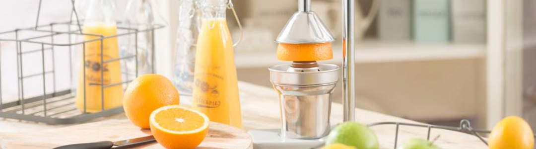 juicer with glass bottle fille with orange juice, half an orange cut in half