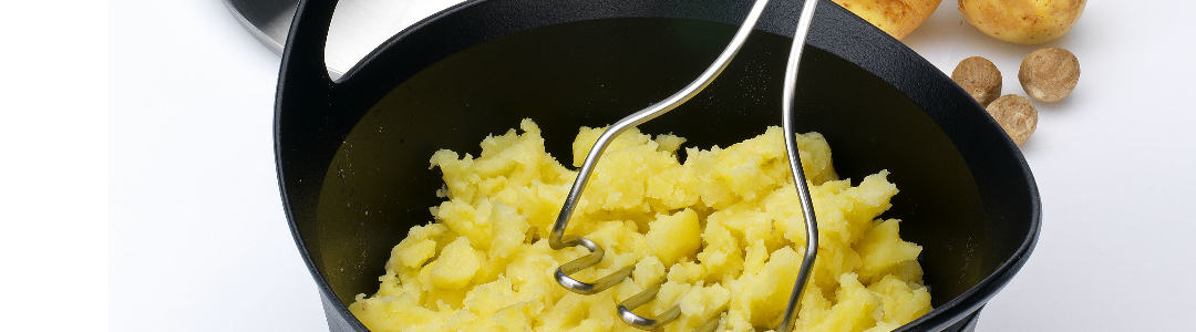 potato being mashed with a masher