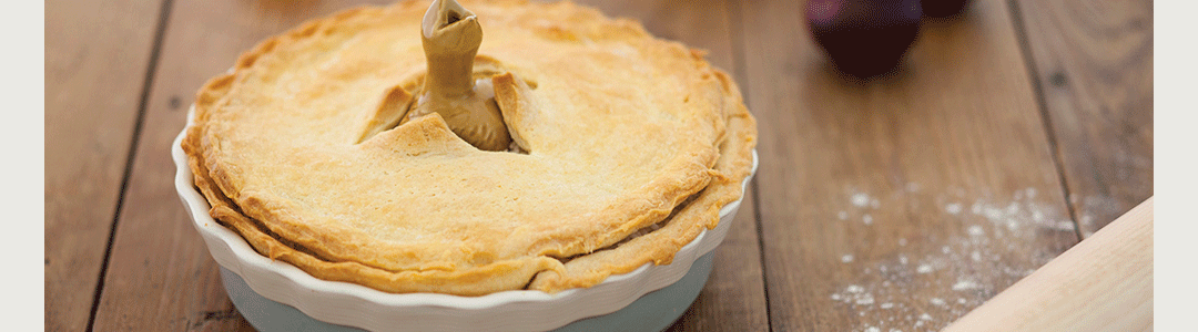 cooked pie in ceramic dish with black bird pie funnel 