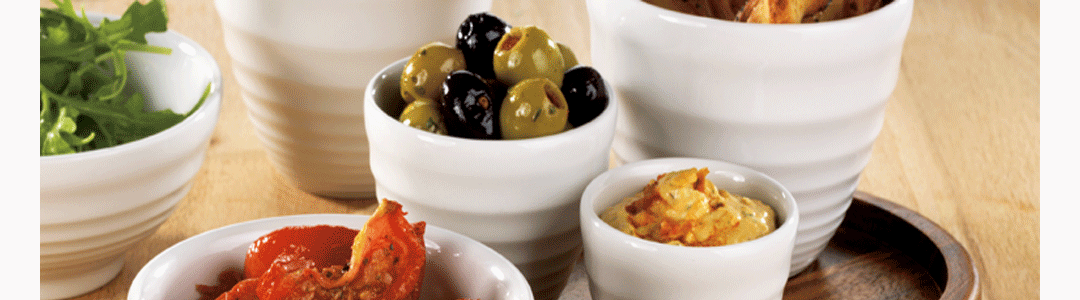 a variety of ramekins placed on a table top, filled with various condiments 