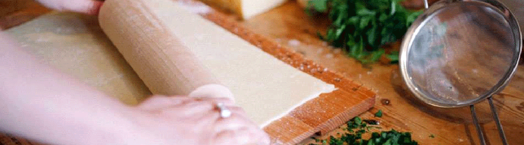 pastry being rolled out on a a table 