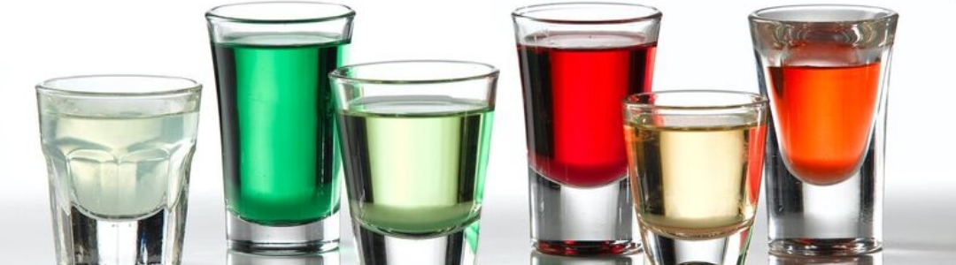 shot glasses filled with different coloured shots 