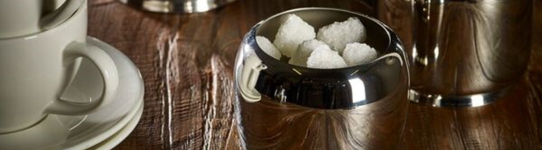 Stainless steel sugar bowl full of sugar cubes