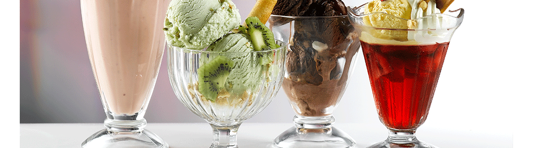 An assortment of four sundae dessert glasses placed side by side 