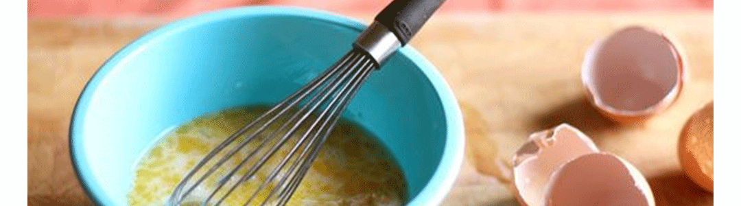whisk being used to beat eggs